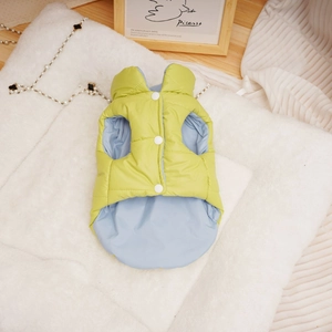 Close-up of lime green quilted dog vest on plush white rug with snap-button closure