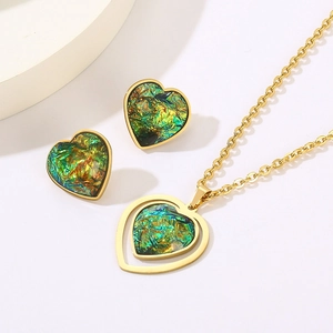 Detailed view of gold heart jewelry set with iridescent green and blue resin inlays