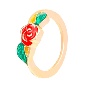 Gros plan détaillé d'une bague dorée ornée d'une rose émaillée rouge et feuilles