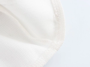 Gros plan sur la texture du tissu en coton blanc avec des détails de couture précis