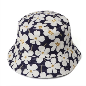 Navy blue reversible cotton sun hat with large white floral print and yellow accents