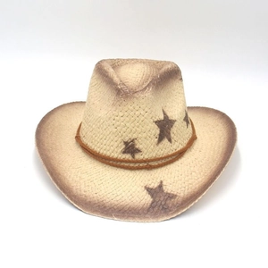 Detail of woven straw cowboy hat featuring brown star patterns and distressed brim edges