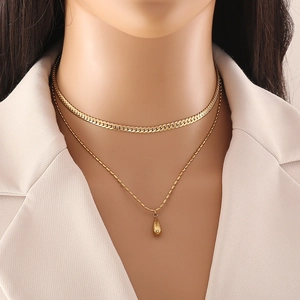 Close-up of double-layer gold necklace featuring flat snake chain and teardrop pendant