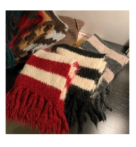 Detailed view of stacked striped knitted cashmere scarves in various colors and soft texture