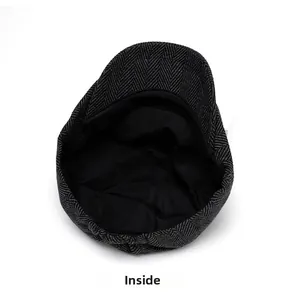 Close-up of black and grey herringbone tweed flat cap showing interior lining and sweatband