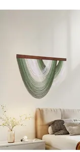 Détail d'une tenture murale bohème avec des franges en coton bicolore vert et blanc