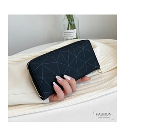 Detail view of black long wallet with geometric triangle pattern held in hand