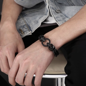 Men's punk skull bracelet in black titanium steel with chunky chain on model's wrist