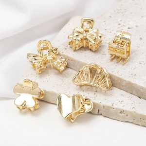Exquisite gold metal mini hair claw clips in butterfly and heart shapes on stone