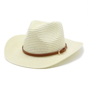 Détail d'un chapeau de cowboy en paille avec bande en cuir marron et boucle dorée décorative