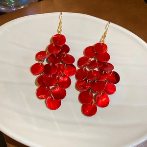 Details von roten, gestuften Muschelscheiben-Ohrringen mit goldenen Haken