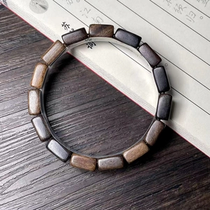 Close-up of wood block bracelet showing natural textures of green and purple sandalwood