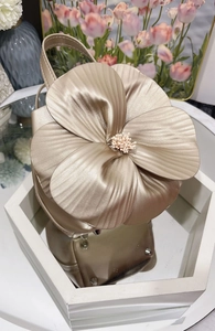 Detailed macro view of 3D metallic floral champagne evening bag on mirrored tray