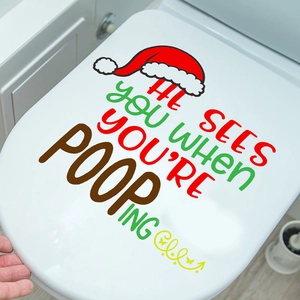 Close-up of funny Christmas hat toilet lid sticker with festive greeting text