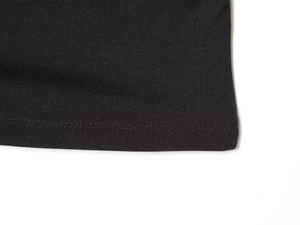 Detailed close-up of the black mesh fabric stitching and hemline on the dress