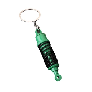 Neon green and black car shock absorber keychain with silver metal ring on white background