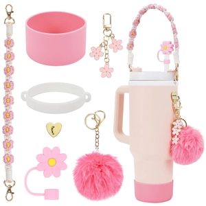 Pink Stanley tumbler accessory set with flower charms, silicone boot, and straw cover