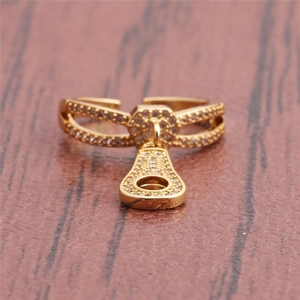 Detailed close-up of a gold zipper ring featuring sparkling pave zircon stones on red wood