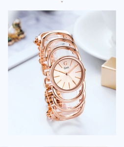 Detail of rose gold bracelet watch with openwork ring strap and minimalist round dial
