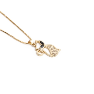 Detailed macro view of a golden fox pendant with black gemstone eyes and box chain