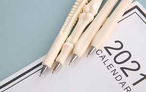 Detailed close-up of bone-shaped ballpoint pens with realistic skeletal texture