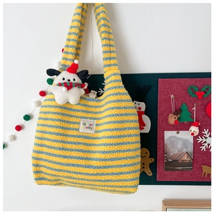 Detail of blue and yellow striped plush shoulder bag with fluffy texture and cute dog charm