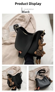 Detail view of black faux leather hobo shoulder bag with a brown knit bunny charm