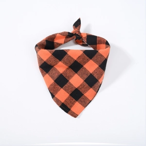 Detail of classic orange and black buffalo plaid cotton pet bandana in a flat lay view