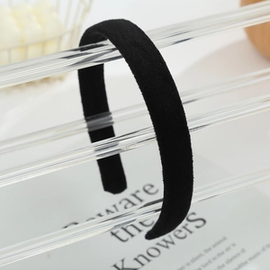 Close-up of a soft black velvet headband displayed on a modern acrylic stand