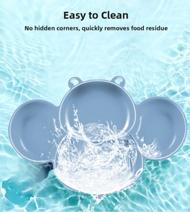Light blue silicone baby plate with partitions on water surface showing easy cleaning