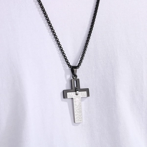 Detailed shot of two-tone stainless steel cross pendant featuring engraved Lord's Prayer text