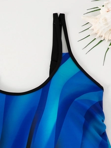 Close-up of tankini top with blue gradient wave print and black elastic straps