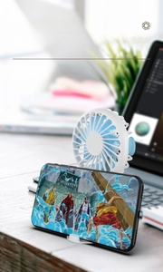 Mini portable fan with blue blades and white base used as a mobile phone holder