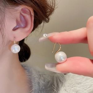 Vue détaillée d'élégantes boucles d'oreilles en or avec perles rondes blanches lisses