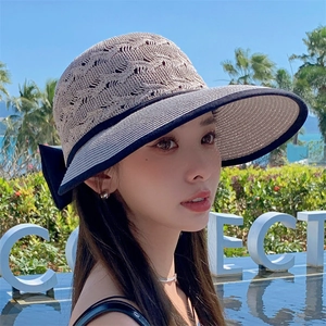 Breathable hollow-knit straw sun hat with navy bow and striped brim for beach vacation