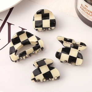 Detailed view of checkered claw clips in black and white with a polished finish