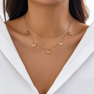 Detail of double-layer gold butterfly necklace with rhinestone tassels on model