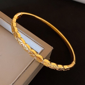 Détail d'un bracelet jonc plaqué or 18 carats avec motif matelassé et pierres de zircon