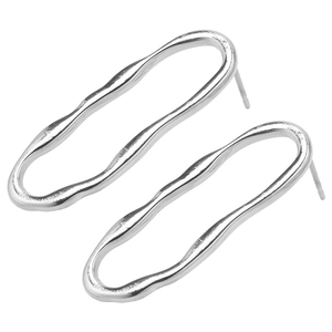 Macro shot of silver wave-shaped oval stud earrings with minimal polished metal texture