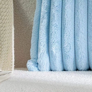 Close-up of light blue faux rabbit fur pillow cover with striped plush texture