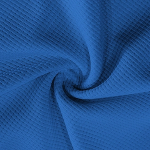Close-up of blue waffle knit fabric texture showing high-quality fiber weave details