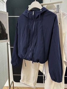Detail of navy blue zip-up hooded jacket with drawstring hem and elastic cuffs