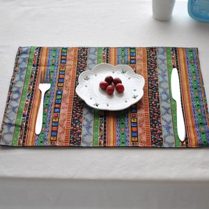 French style colorful striped linen placemat shown with white plate and cutlery