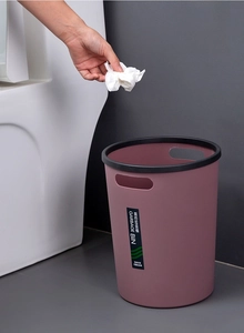 Macro view of a modern dark pink trash bin featuring a wide black press ring and handles