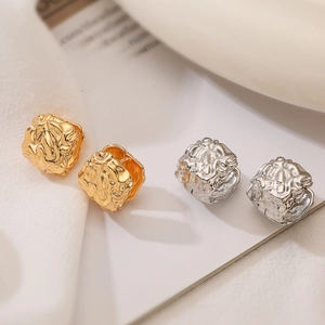 Minimalist square gold and silver earrings with irregular lava texture finish