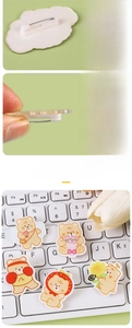 Detail view of cute cream bear acrylic pins showing safety pin back and laser-cut edges