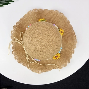 Close-up of girls sun hat with woven texture, yellow sunflowers and colorful beads