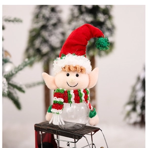 Detail of Christmas elf candy jar with red hat and striped scarf on mini iron sledge