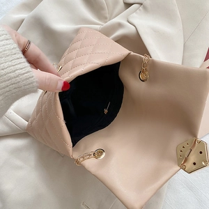 Chic beige quilted crossbody bag with gold hardware and chain strap shown from above