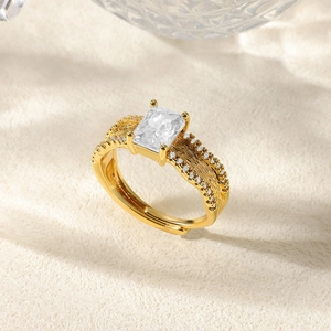 Detailed macro view of gold-plated ring with rectangular zircon and textured feather band